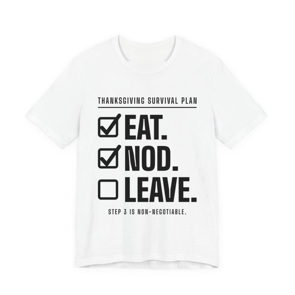 White t-shirt printed in dark ink with a “Thanksgiving Survival Plan” checklist: Eat. (checked), Nod. (checked), Leave. (not yet), with “Step 3 is non-negotiable”