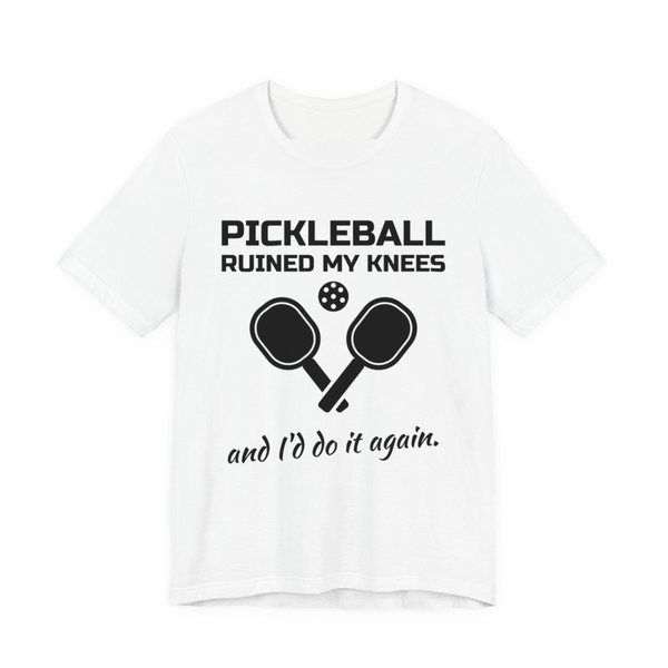 White t-shirt printed in dark ink with “Pickleball Ruined My Knees” above two crossed paddles and a ball, signed off with “and I'd do it again.”